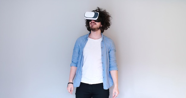 Uomo felice che ottiene esperienza utilizzando gli occhiali per cuffie VR della realtà virtuale, isolati su sfondo bianco