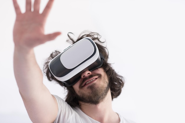 Uomo felice che ottiene esperienza utilizzando gli occhiali per cuffie VR della realtà virtuale, isolati su sfondo bianco