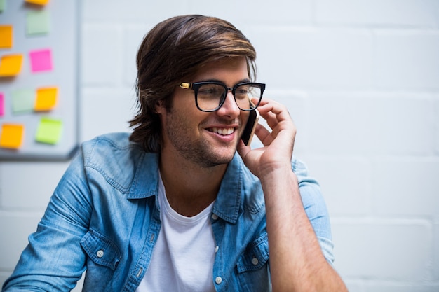 Uomo felice che parla sul telefono in ufficio