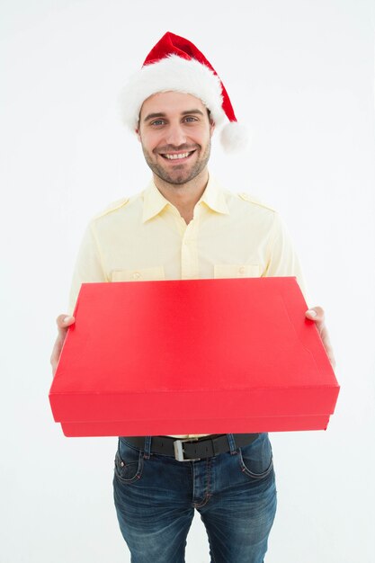 Uomo felice che porta il cappello di Santa mentre tenendo regalo rosso