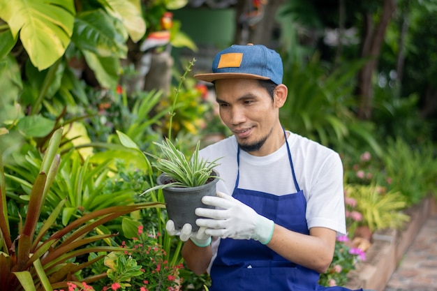 Uomo felice che tiene vaso floreale nel negozio dell'ornamento del giardino