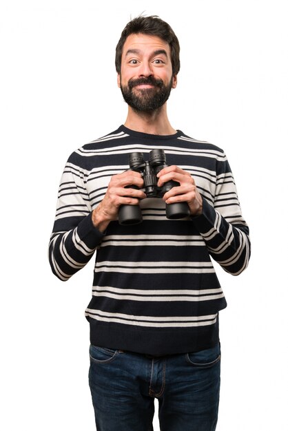 Uomo felice con la barba con il binocolo