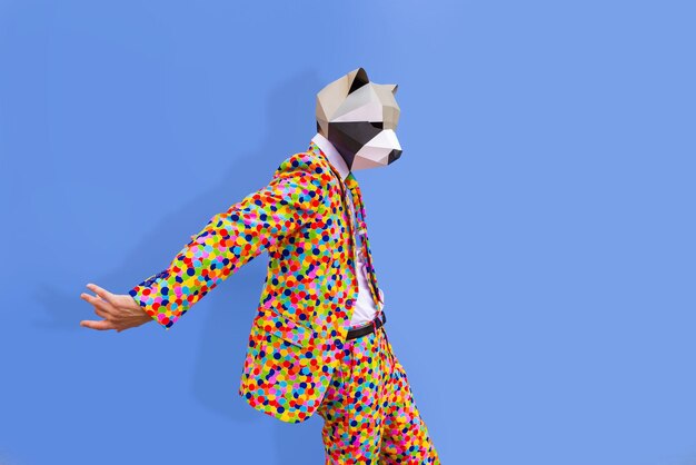 Uomo felice con maschera divertente low poly sulla parete colorata