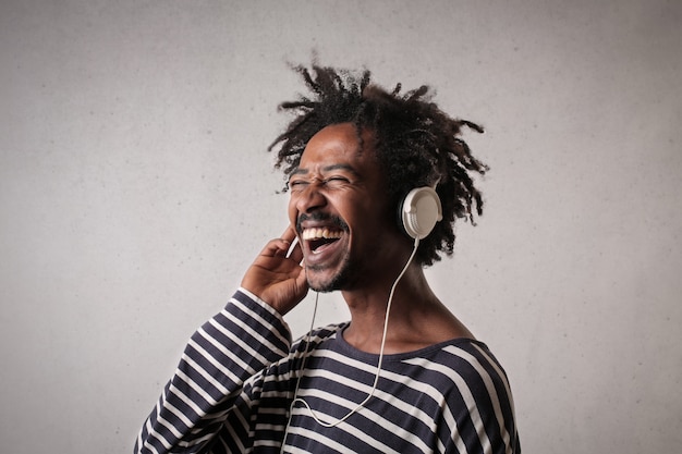 Uomo felice di afro che ascolta la musica