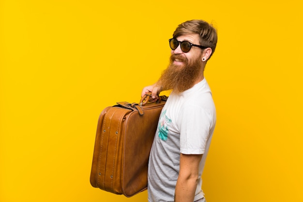 Uomo felice di Redhead con la barba lunga che tiene una cartella dell'annata