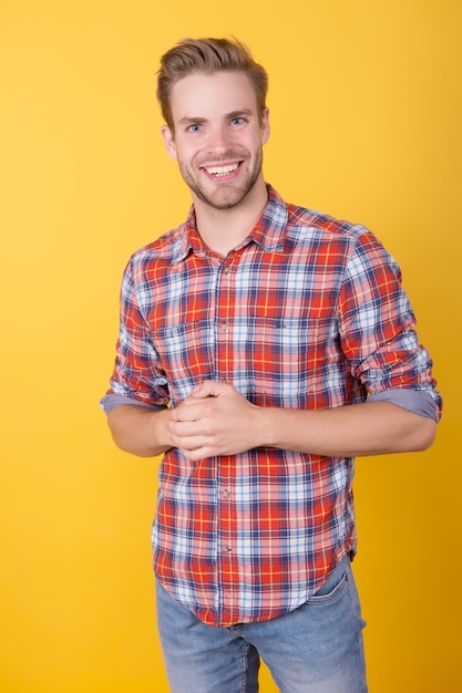 Uomo felice in camicia a scacchi su sfondo giallo sexy e fiducioso Ragazzo uomo barbiere stile casual con cool acconciatura moda modello in camicia estate e primavera collezioni maschili essere felice