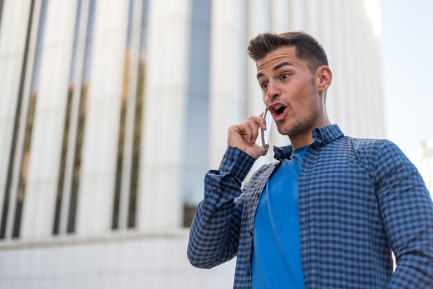 Uomo felice sorpreso talikng sul telefono cellulare