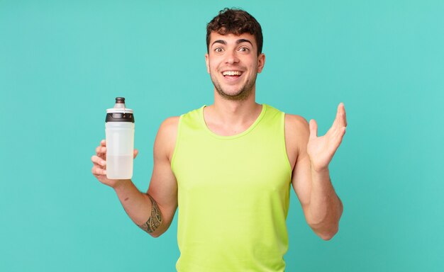 Uomo fitness sentirsi felice, sorpreso e allegro, sorridente con atteggiamento positivo, realizzando una soluzione o un'idea