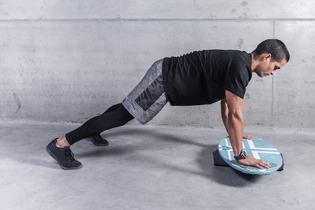 Uomo forte che si esercita con il bordo d'equilibratura