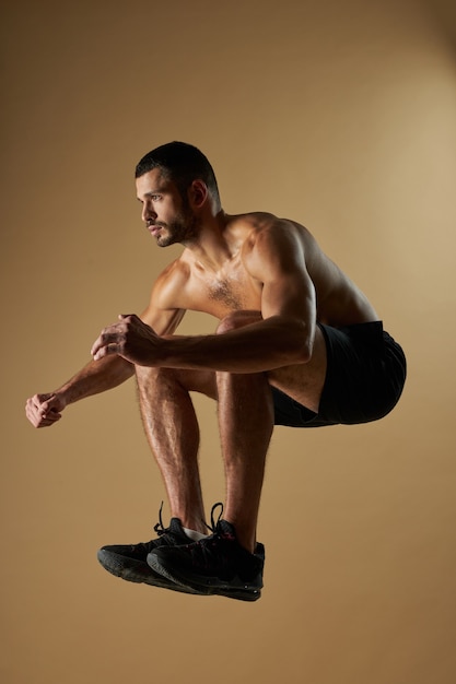 Uomo forte e adorabile atleta che si scalda mentre si allena in palestra