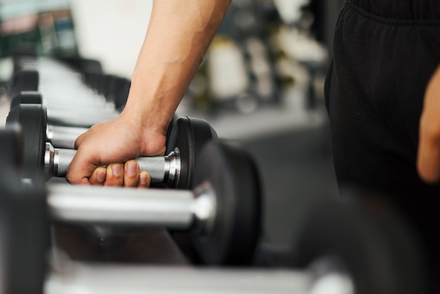 uomo forte fitness in posa corpo muscoloso e facendo esercizi per culturista in palestra