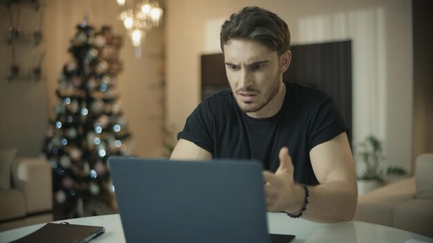 Uomo frustrato che lavora al computer portatile a casa Il ragazzo infastidito ha problemi