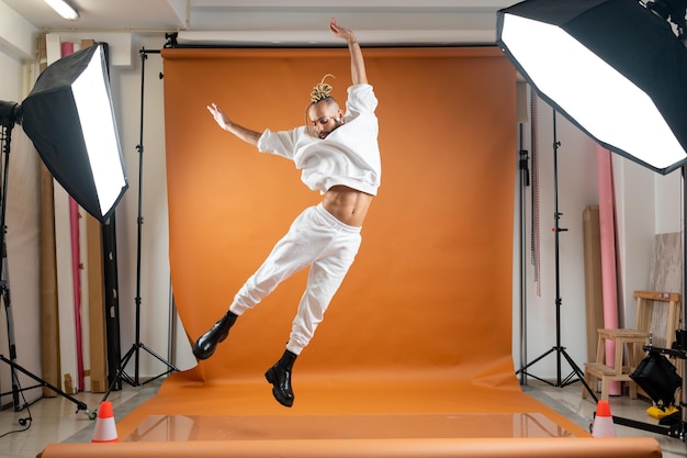 Uomo gay che balla in studio fotografico