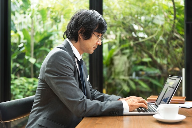 Uomo giapponese che lavora su un computer portatile