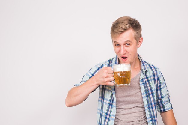 uomo gioioso con la barba con un boccale di birra su una parete blu, alcol