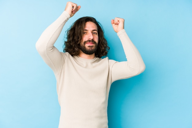 Uomo giovane capelli lunghi su una parete blu che celebra