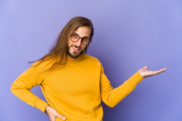 Uomo giovane caucasico capelli lunghi isolato che esprime emozioni