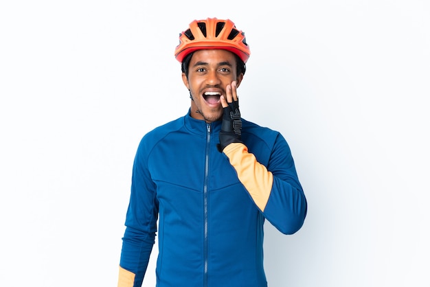 Uomo giovane ciclista con trecce sulla parete isolata con espressione facciale sorpresa e scioccata