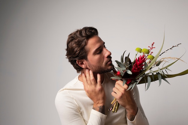 Uomo giovane e sensibile con i fiori