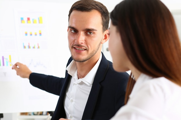 Uomo giovane insegnante bello in tuta con gruppo di lavoro