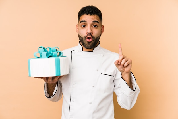 Uomo giovane panettiere che tiene una torta