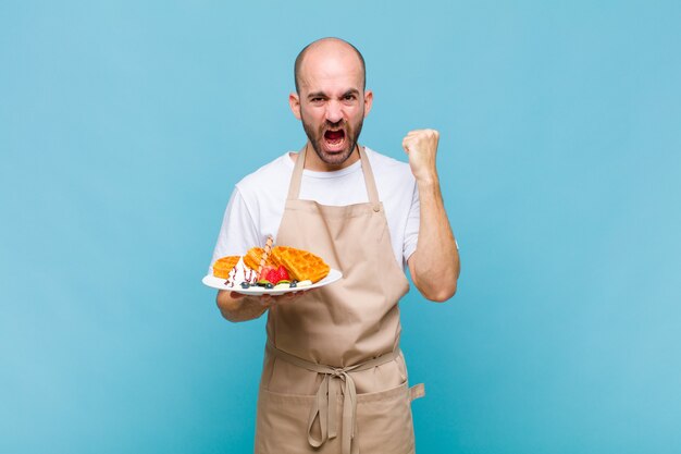 Uomo giovane panettiere con cialde