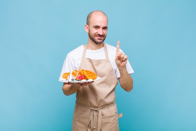 Uomo giovane panettiere con cialde