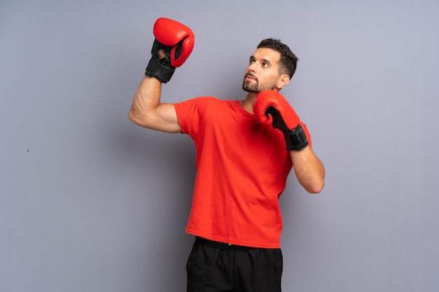 Uomo giovane sportivo con guantoni da boxe