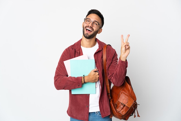 Uomo giovane studente isolato su sfondo bianco sorridendo e mostrando il segno di vittoria