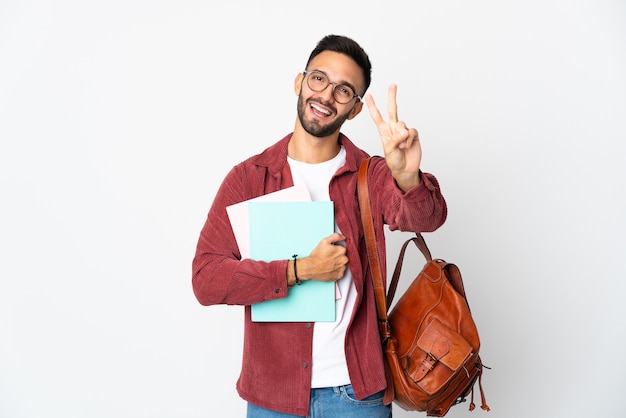 Uomo giovane studente isolato su sfondo bianco sorridendo e mostrando il segno di vittoria