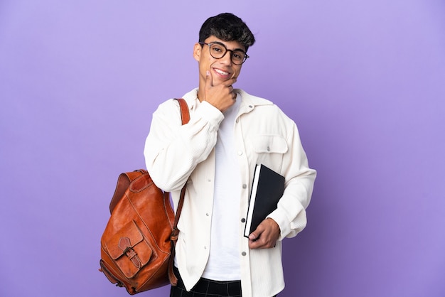 Uomo giovane studente su viola isolato felice e sorridente