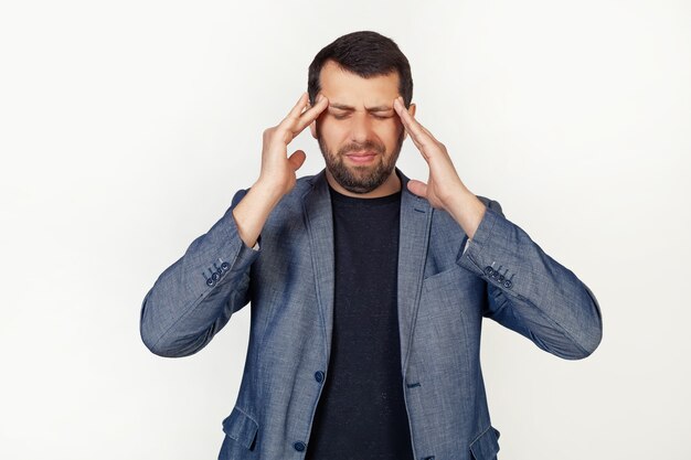 Uomo giovane uomo d'affari con la barba con la mano sul mal di testa a causa dello stress. Soffre di emicrania.