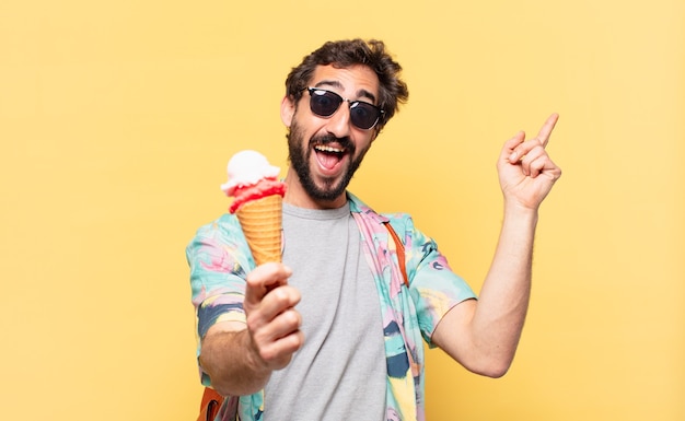 Uomo giovane viaggiatore pazzo che celebra con successo una vittoria e tiene un gelato