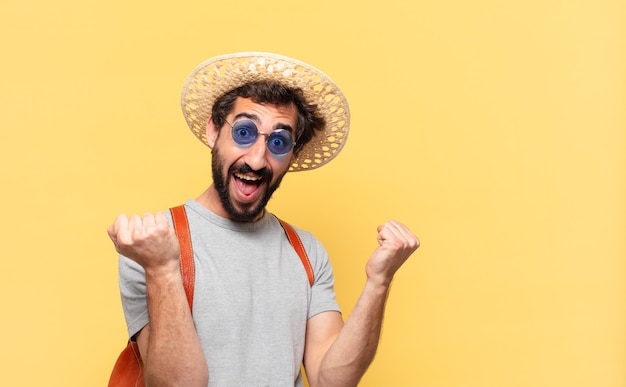 Uomo giovane viaggiatore pazzo che celebra con successo una vittoria