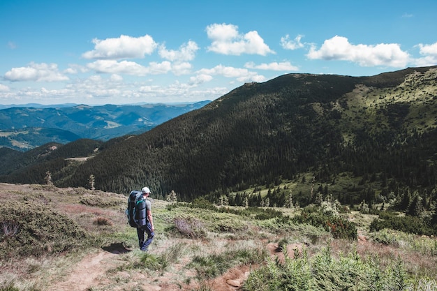 Uomo giovane viandante in montagna. percorso di trekking estivo. copia spazio.