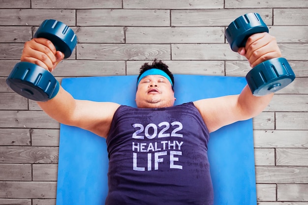 Uomo grasso che si esercita con il testo della vita sana del 2022