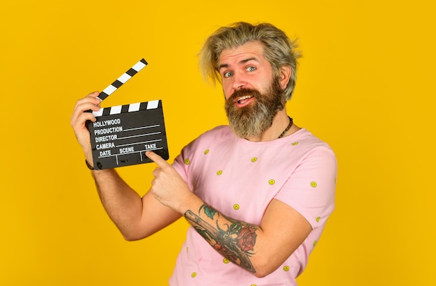 Uomo hipster con batacchio di film Uomo con batacchio di film Attore professionista maschio pronto per le riprese del film si prepara per il nuovo produttore di scene che tiene l'azione del ciak del film