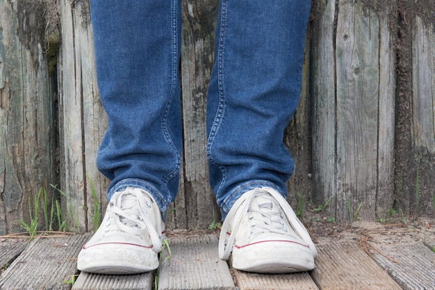 Uomo hipster con scarpe di moda sul ponte di legno