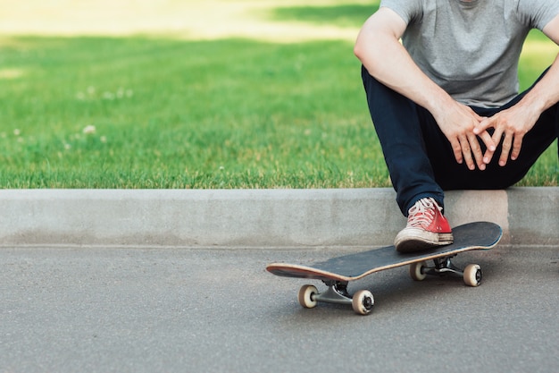 Uomo hipster irriconoscibile con skateboard