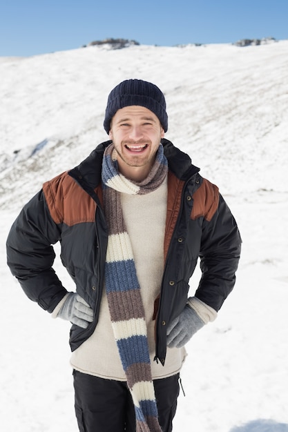 Uomo in abbigliamento caldo in piedi sul paesaggio innevato