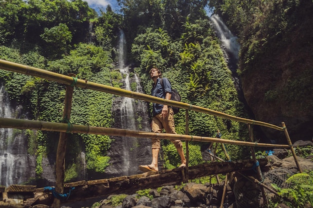 Uomo in abito turchese alle cascate di Sekumpul nelle giungle dell'isola di Bali Indonesia Bali Travel Concept