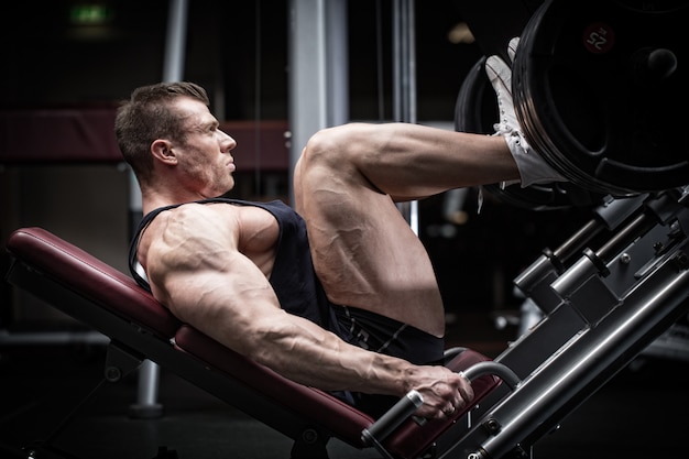 Uomo in allenamento in palestra con leg press