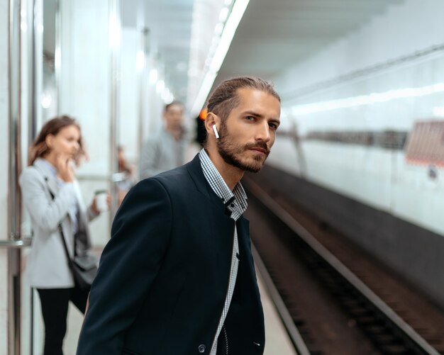 Uomo in attesa di un treno alla stazione della metropolitana