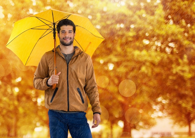 Uomo in autunno con l'ombrello nella foresta
