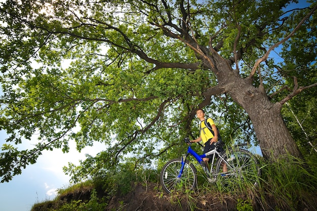 Uomo in bicicletta che viaggia nella foresta