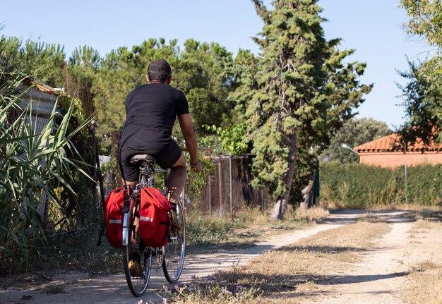 Uomo in bicicletta con le bisacce