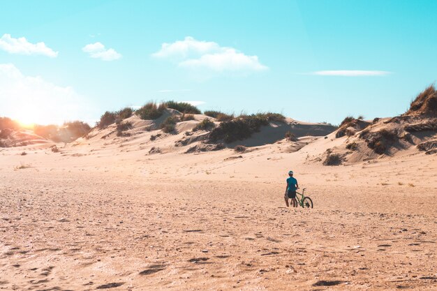 Uomo in bicicletta in spiaggia. Sport e concetto di vita attiva in estate e all'aperto.