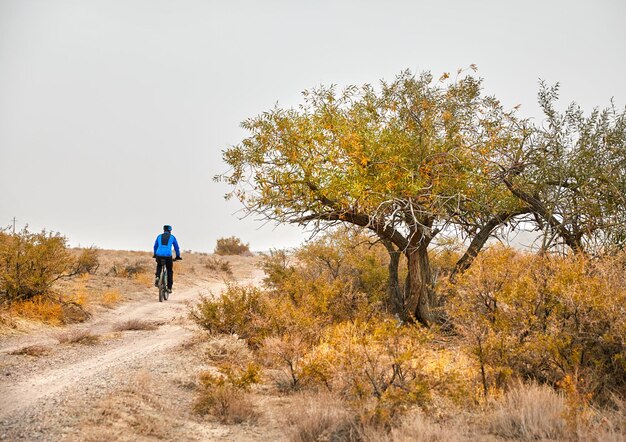 Uomo in bicicletta nel deserto