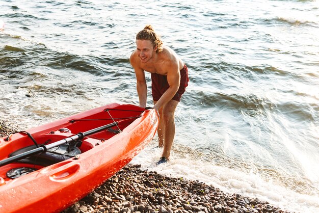 Uomo in buona salute su un kayak nell'oceano, lanciando una barca