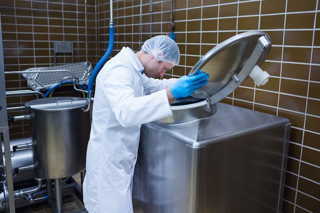 Uomo in camice da laboratorio che esamina la macchina